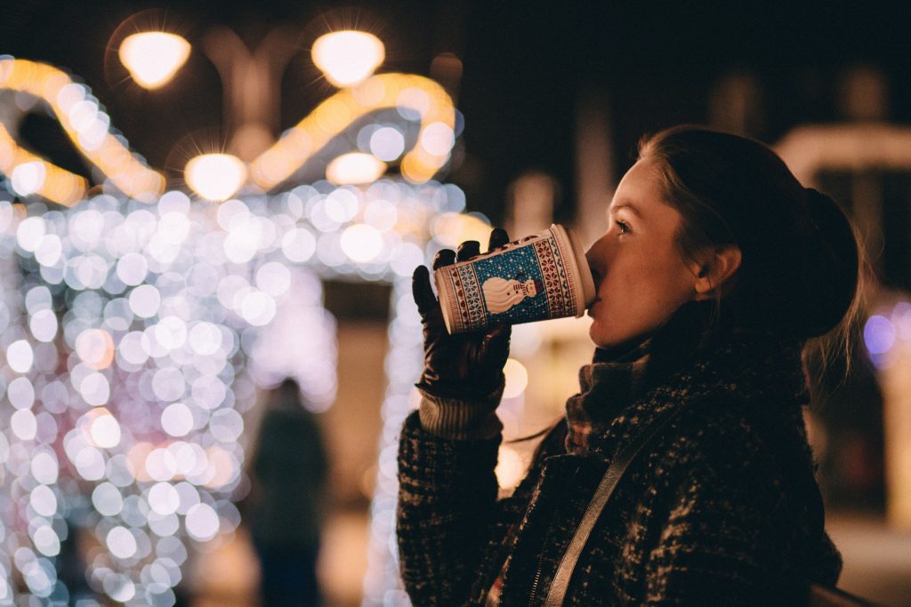 Woman drinking warm beverage on street