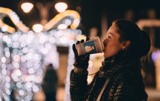 Woman drinking warm beverage on street